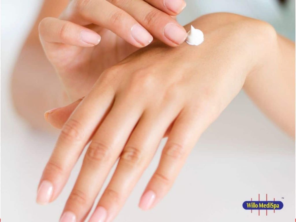 hands of a woman applying skin care product 